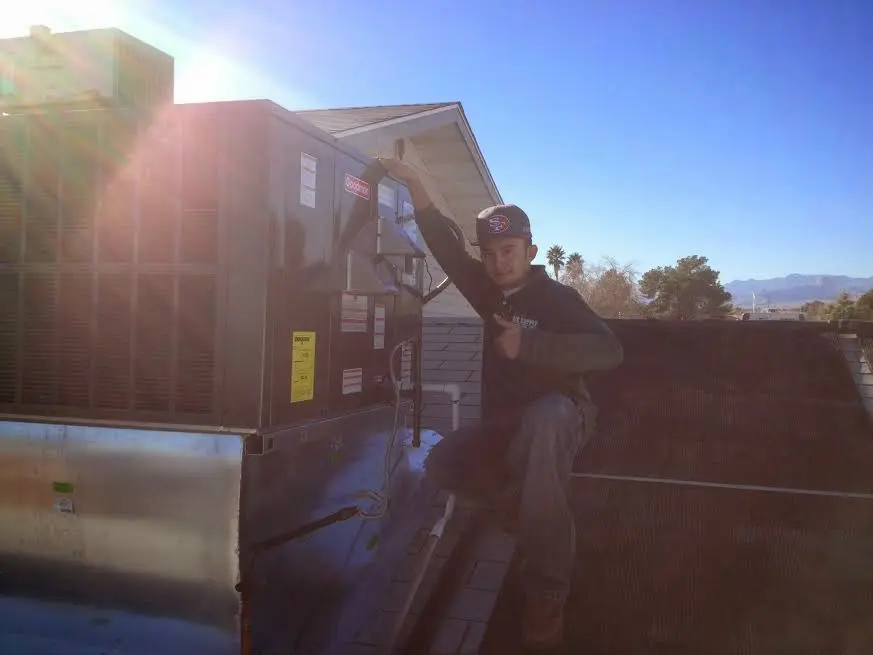 HVAC technician performing HVAC Inspection on a rooftop unit in Roswell